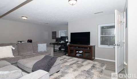 A living room with a grey couch and a black television.