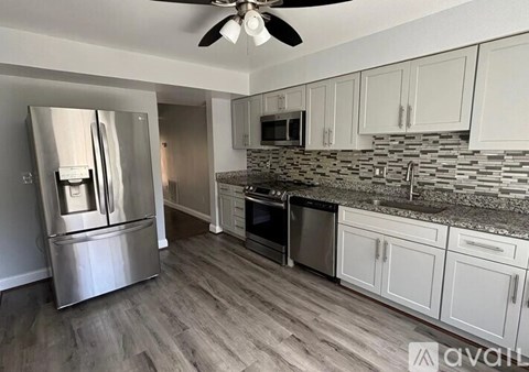 A kitchen with a stainless steel refrigerator and a ceiling fan.