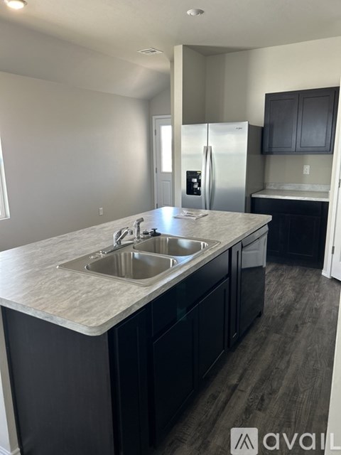 A kitchen with a sink and a refrigerator.