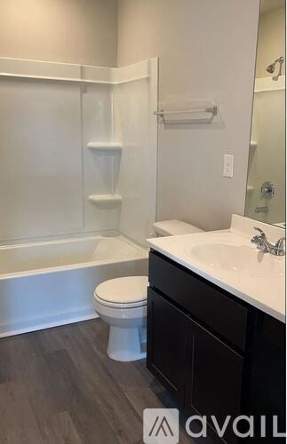 A white toilet sits in a bathroom next to a sink.