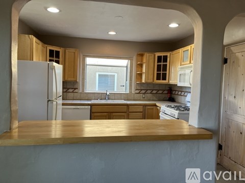 A kitchen with wooden cabinets and a white refrigerator.