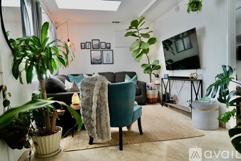 A living room with a grey couch and a green chair.