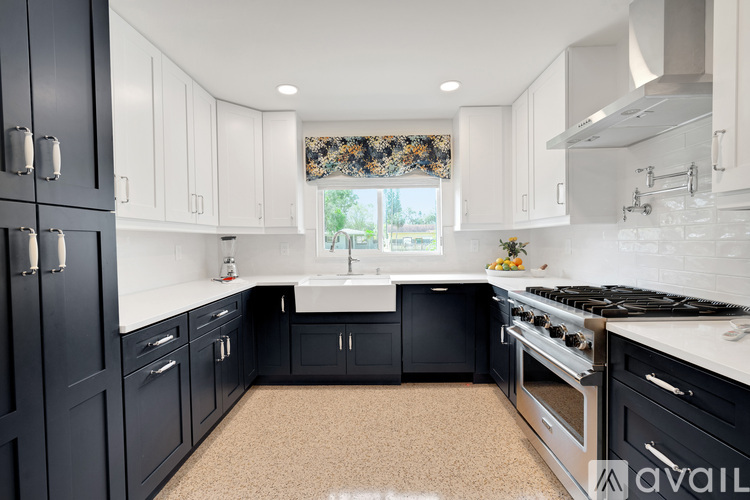 A kitchen with black cabinets and a white countertop.