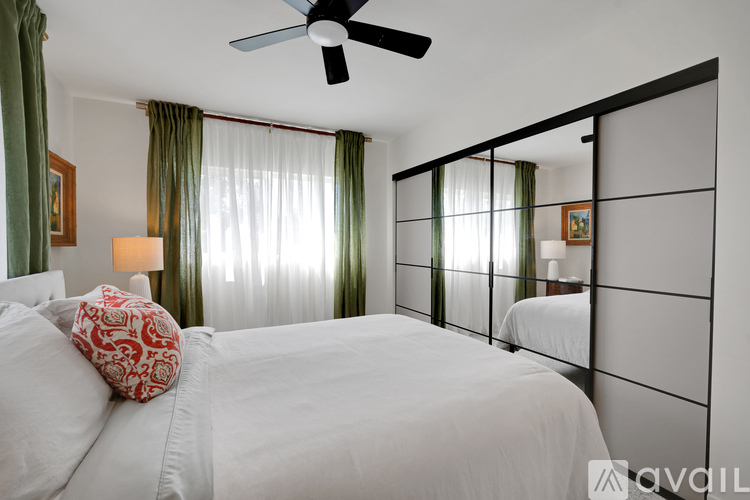 A bedroom with a large bed and a ceiling fan.