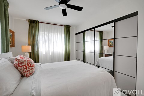 A bedroom with a large bed and a ceiling fan.