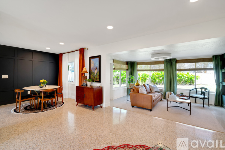 A living room with a dining table and chairs, a sofa, and a coffee table.