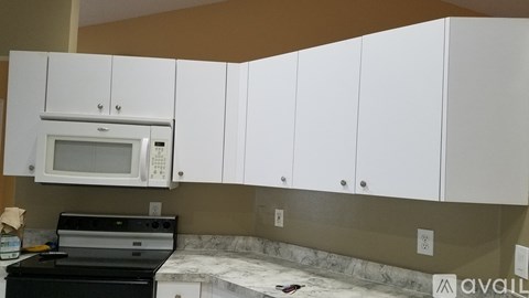 A kitchen with white cabinets and a black stove top oven.