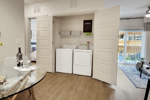 A modern kitchen with a glass table and a wine bottle on it.