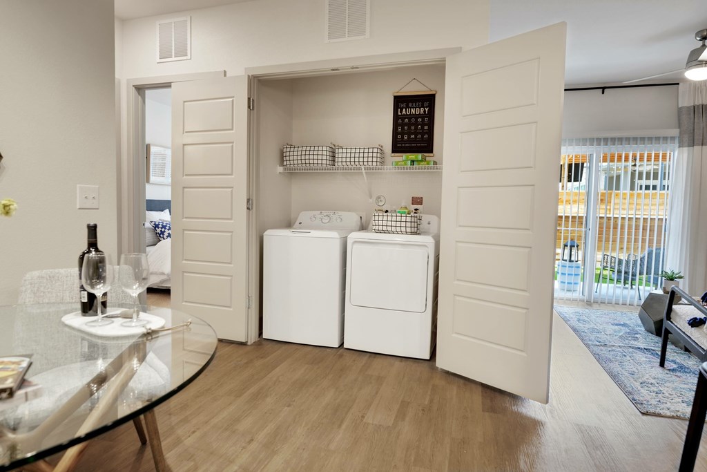 A modern kitchen with a glass table and a wine bottle on it.