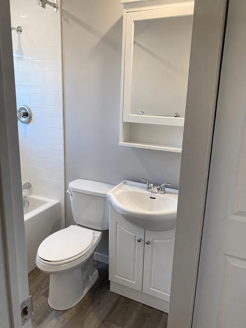 A white toilet and sink in a bathroom.