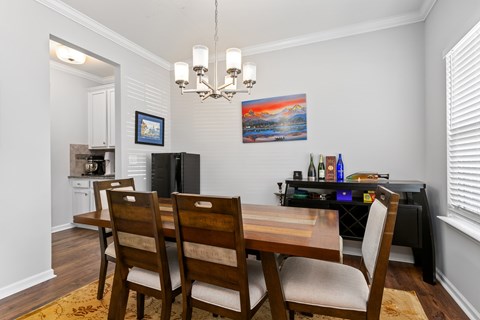 A dining room with a wooden table and chairs.
