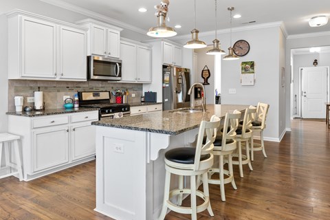 A kitchen with white cabinets and a granite countertop.