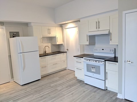 A kitchen with white appliances and cabinets.