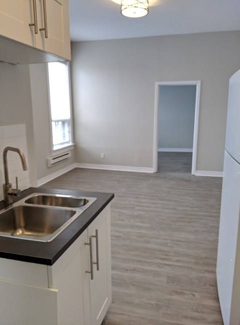 A kitchen with a sink and a refrigerator.