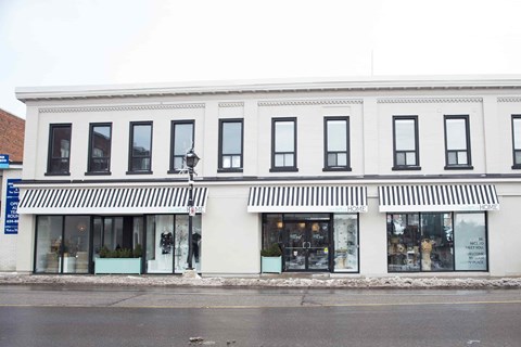 A white building with black trim and awnings.