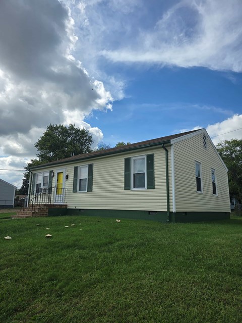 A house with a green lawn and a yellow door.
