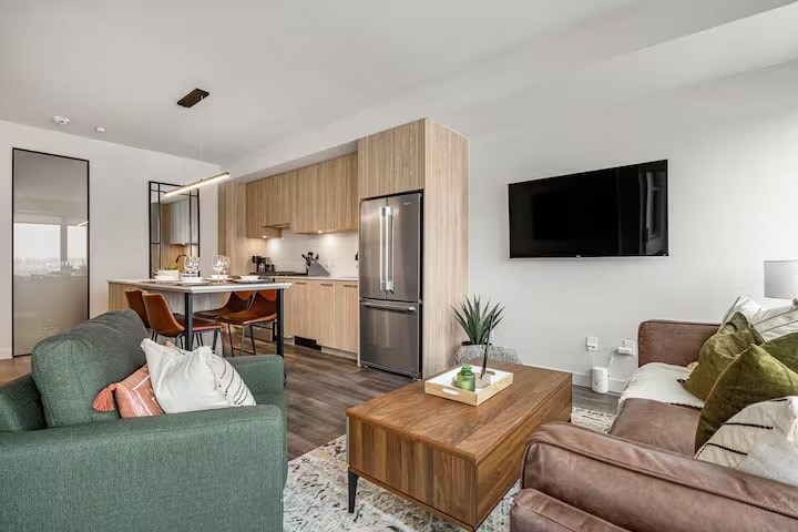 A modern living room with a green couch and a wooden coffee table.