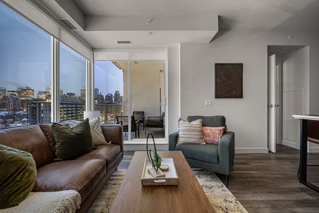 A living room with a brown leather couch and a wooden coffee table.