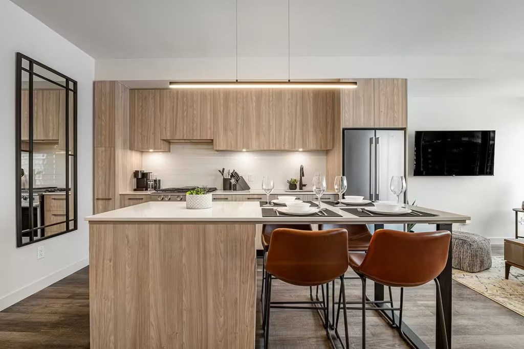 A modern kitchen with wooden cabinets and a center island.