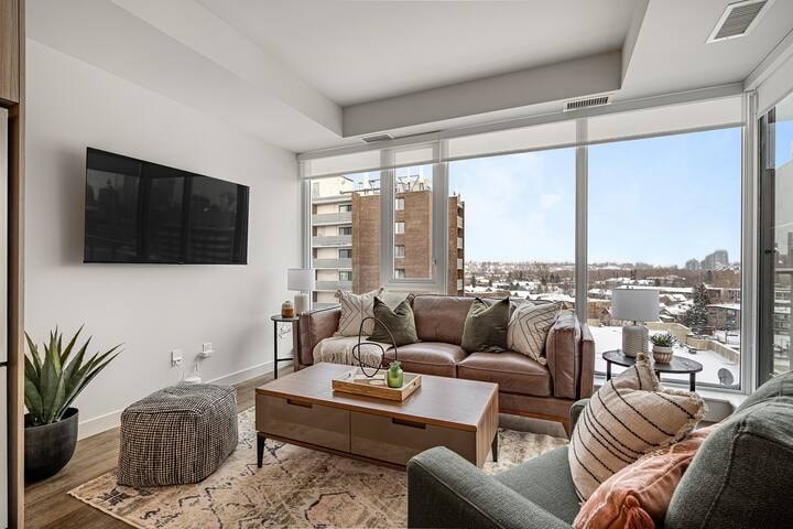 A living room with a couch, a coffee table, and a flat screen TV.