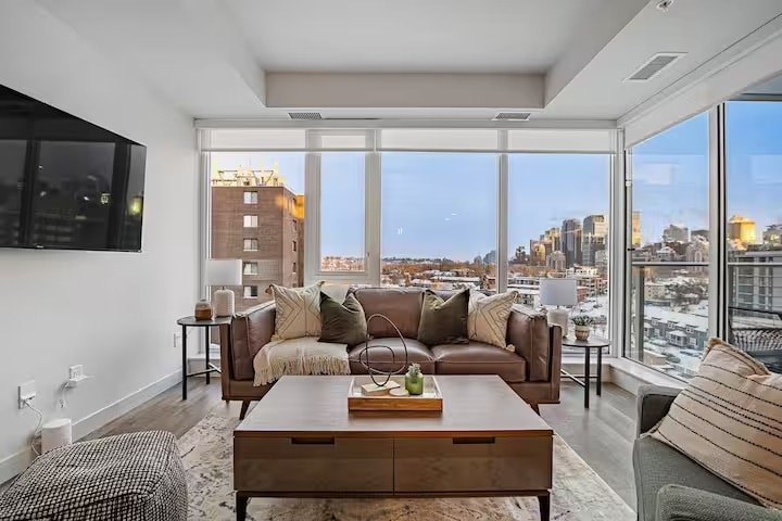 A living room with a large window overlooking a cityscape.