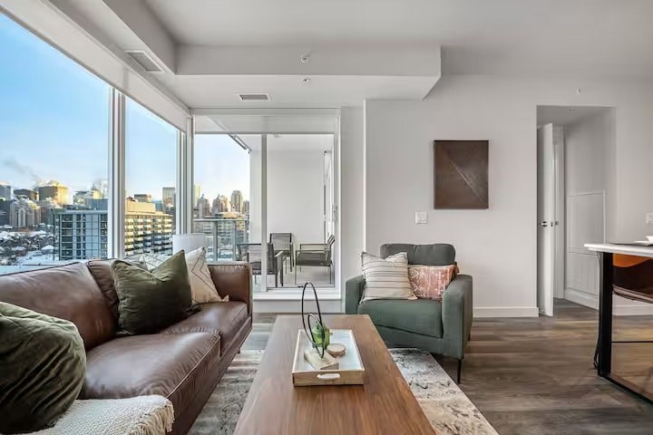 A living room with a brown couch and a green chair.