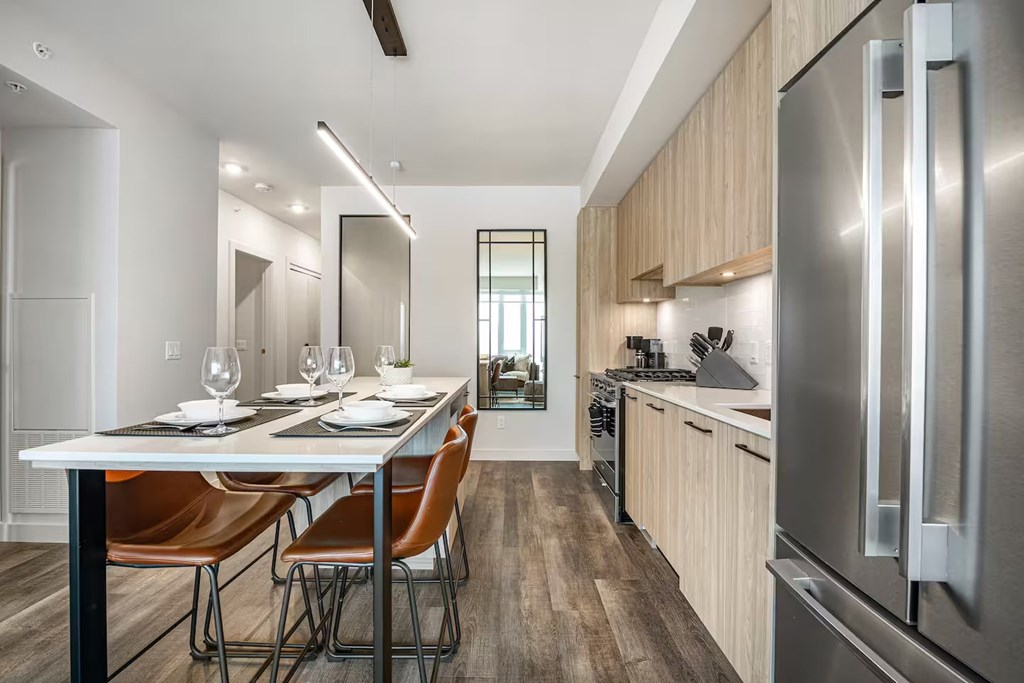 A modern kitchen with a dining table set for two.