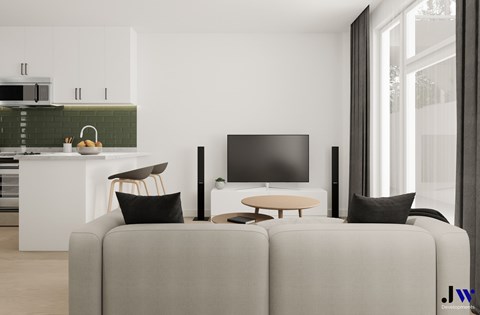 A modern living room with a grey sofa, a television, and a kitchen area in the background.