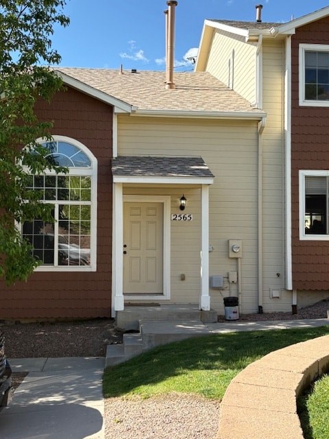 A house with a brown and beige exterior has a white door with the number 2563 on it.