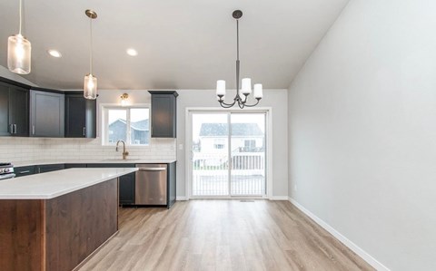 A kitchen with a white counter top and wooden cabinets.