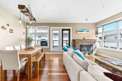 A modern living room with a dining table and a fireplace.