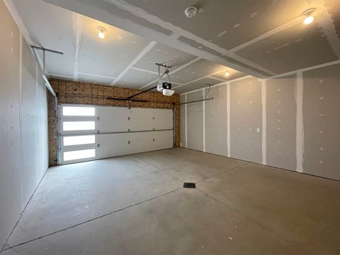 A room with a concrete floor and a window on the left side.