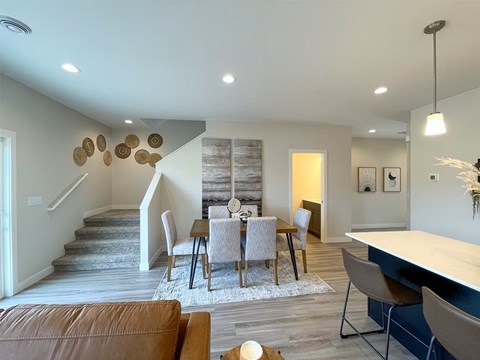 A modern dining room with a wooden table and chairs.