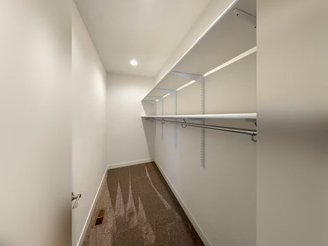 A long hallway with a carpeted floor and white walls.