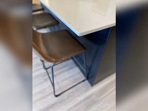 A brown chair is placed in front of a white table.