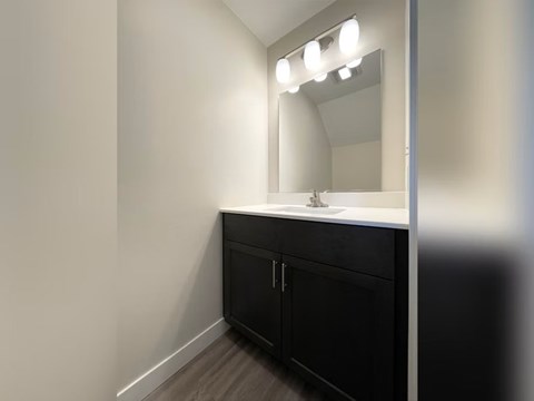 A bathroom vanity with a mirror and lights above it.