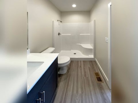 A bathroom with a toilet, sink, and shower.