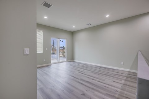 A room with a wooden floor and a sliding glass door.