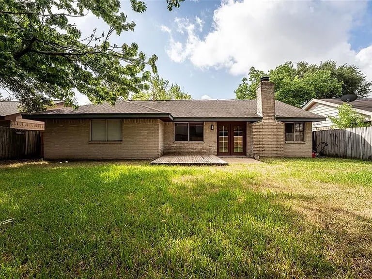 A house with a brown roof and a brown fence.