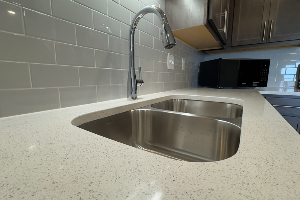 A stainless steel kitchen sink with a modern faucet.