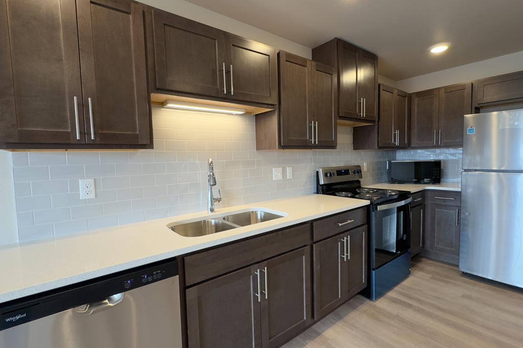 A kitchen with brown cabinets and a white counter.