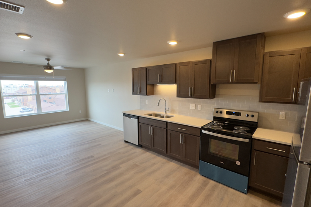 A kitchen with brown cabinets and a blue stove top oven.