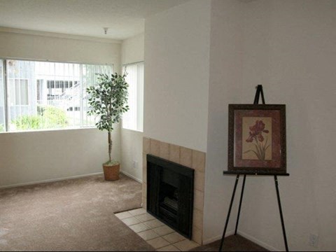 a living room with a fireplace and a painting on a tripod