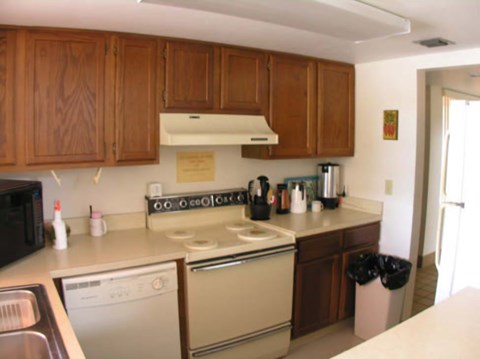 A kitchen with wooden cabinets and a white stove top oven.