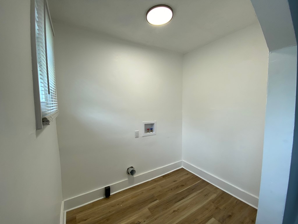 A room with a white wall and a wooden floor.