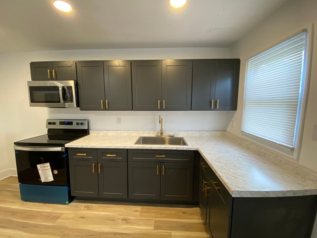 A kitchen with black cabinets and a white countertop.