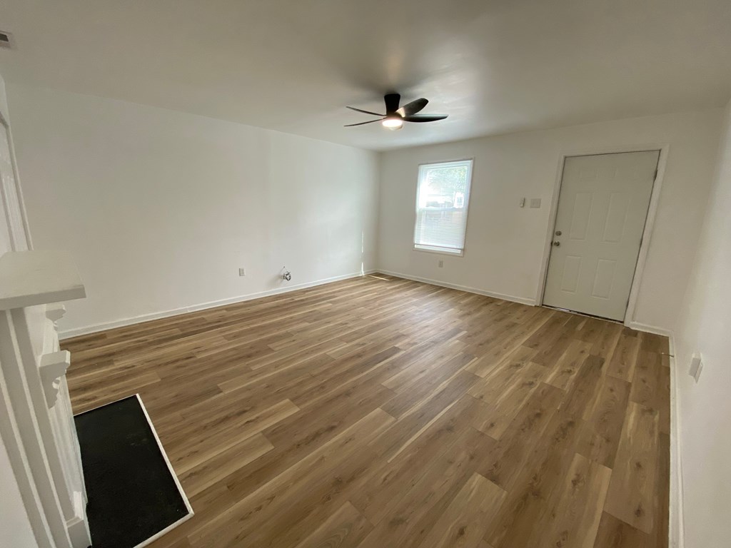 A room with wooden flooring and a ceiling fan.