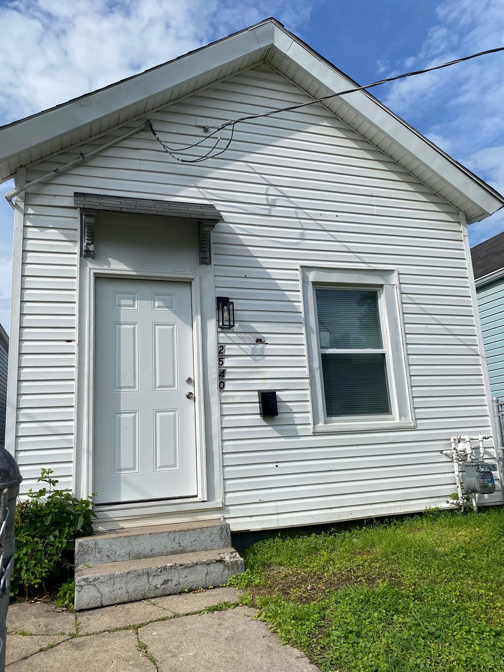 A small white house with a grey door and a window.