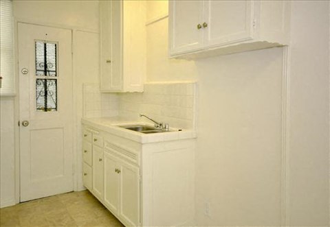 a white kitchen with a sink and a door