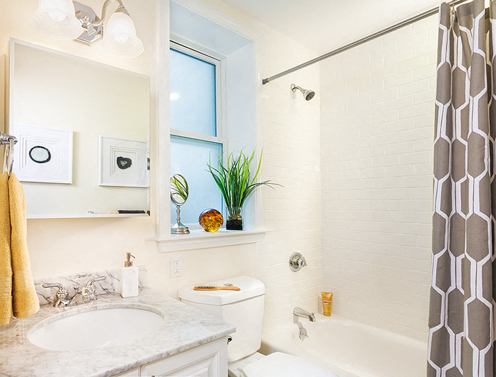 a white bathroom with a window and a sink and a toilet